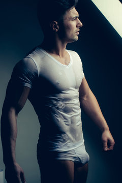 Muscular man in wet shirt