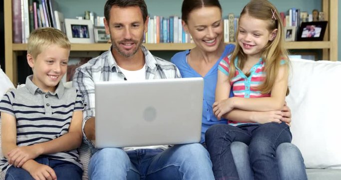 A happy family enjoying a moment with a computer