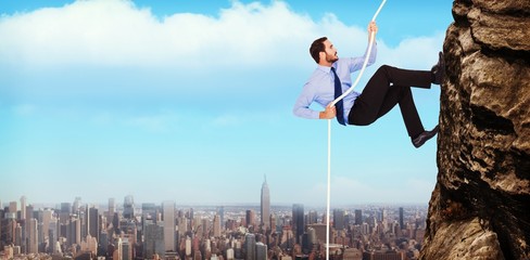Composite image of businessman pulling a rope with effort