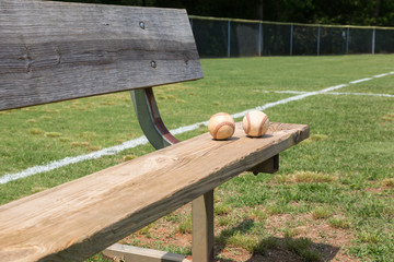 Baseball on a bench in a little league field