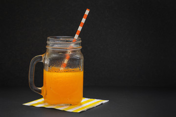 Mug with fresh orange juice dark background