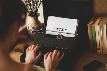 Create against young woman using typewriter