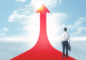 businessman standing on a red arrow