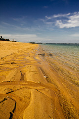 langer, einsamer Sandstrand und Meer bei strahlend blauem Himmel auf Bali in Indonesien