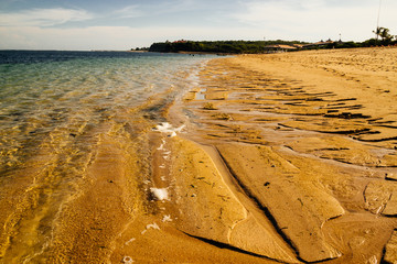 langer, einsamer Sandstrand und Meer bei strahlend blauem Himmel auf Bali in Indonesien