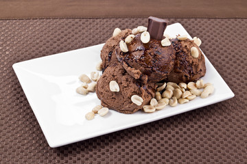 chocolate ice cream in plate with peanuts