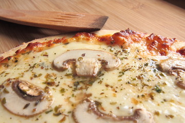 Four cheese pizza with fresh mushrooms on top