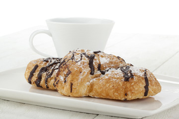 chocolate croissants on plate with cup