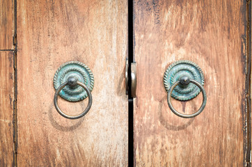 Old chinese style door handles on brown wooden door