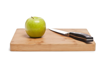 green apple and knife on a board