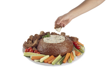 hand dipping a pumpernickel
