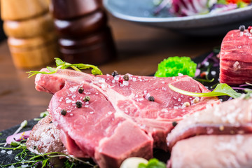 Steak.Beef steak.Meat.Portioned meat.Raw fresh meat.Sirloin steak.T-Bone steak. Flank steak. Duck breast. Vegetable decoration. Portioned meat prepared for processing in a restaurant or hotel kitchen.
