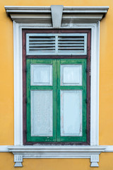 Fototapeta na wymiar Green window on a yellow wall (Portugese style window)