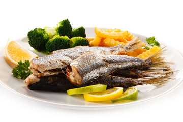 Fried herrings, chips and vegetables