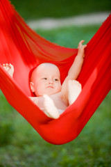 Newborn baby boy relaxing in a hammock