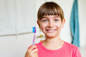 Young girl holding toothbrush