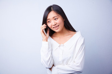 Chinese woman in white talking on a cell phone