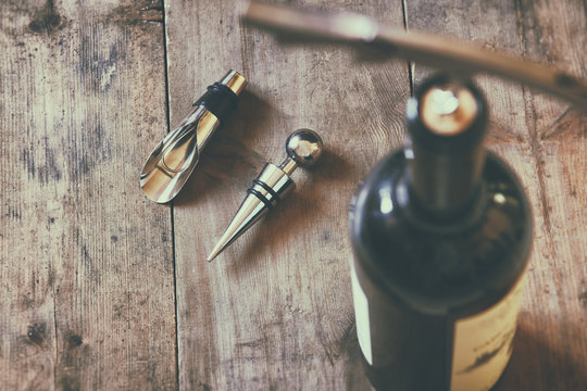 top view image of red wine bottle and corkscrew