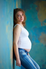 Pregnant woman in jeans in studio