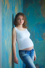 Fototapeta premium Pregnant woman in jeans in studio