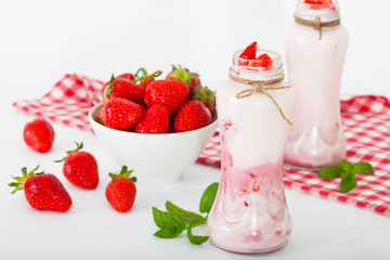 Fresh strawberry fruits and yogurt in small bottles