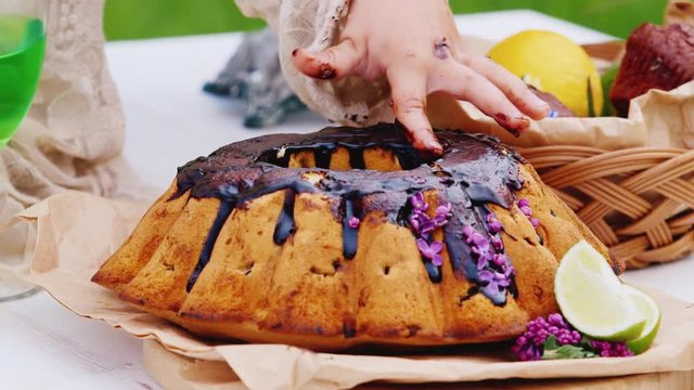 Hand girl licks a chocolate cake