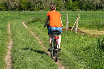 Frau macht eine Fahrradtour auf dem Feldweg