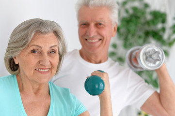 sporty senior couple with dumbbells