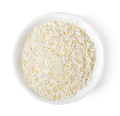 Bowl of grated coconut on white background, top view
