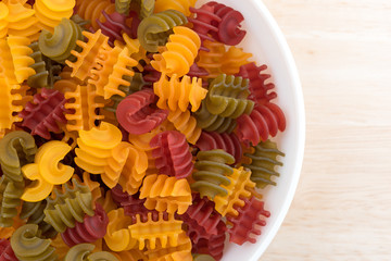Corn vegetable radiatore pasta in a bowl on wood table top 