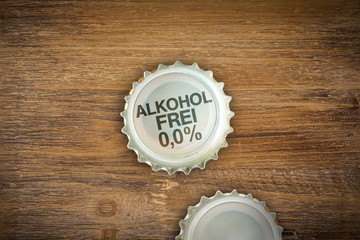 Bier-Kronkorken mit der Botschaft Alkoholfrei 0,0% auf alten Holz