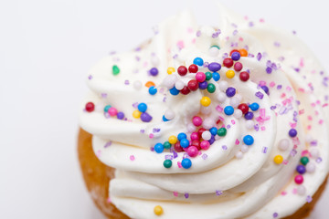muffin decorated with white icing and sprinkles.