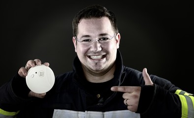 Feuerwehrmann mit Rauchmelder in Arbeitskleidung