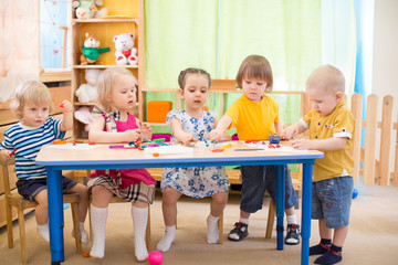 kids group learning arts and crafts in kindergarten playroom