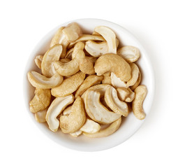 Bowl of cashew nuts isolated on white, top view
