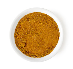 Bowl of curry powder isolated on white, top view