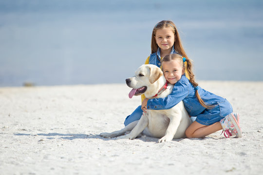 kids with labrador on the beach 