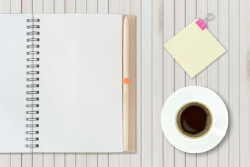 Open notebook on wooden background with coffee cup and yellow no