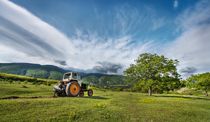 Тractor digging a channel for drainage of water in the mountain © vrstudio
