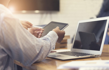 man's hand working with tablet, document and laptop computer not