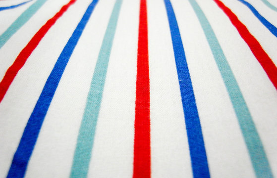 Close-up of vintage fabric with colorful stripes on cotton.