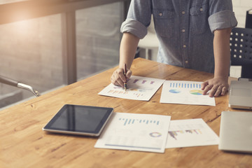woman's hand working with document, tablet and laptop computer n