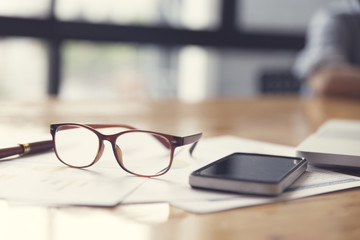 eyeglasses, business document and laptop computer notebook on wo