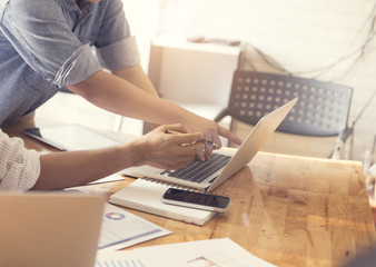 people working with laptop computer and business document