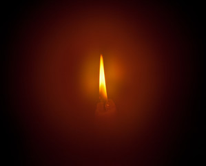 The flame of a candle in the dark