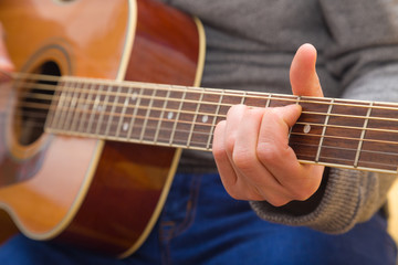 Fototapeta premium Hände eines jungen Mannes der Gitarre spielt