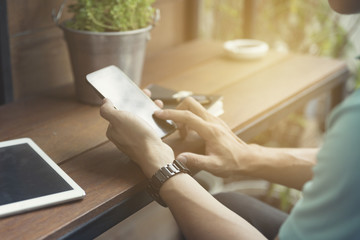 man's hand using smartphone with digital tablet
