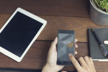 man's hand using smartphone with digital tablet