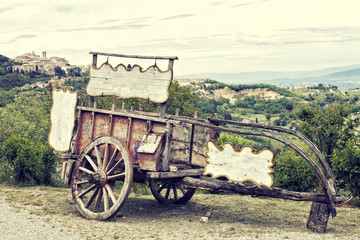 Obraz premium Old wooden cart against vineyards, Tuscany, Italy. Processing in retro style