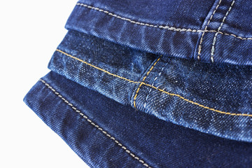 Various seams on blue denim trousers on a white background